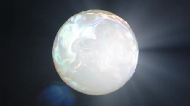 A pearl glowing with captured moonlight in a dark space