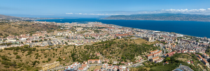 Naklejka premium Aerial panorama of the Strait of Messina. It is a narrow strait between the eastern tip of Sicily and the western tip of Calabria, in Southern Italy. It connects the Tyrrhenian Sea with the Ionian Sea