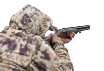 A hunter in camouflage at the shooting range calibrates the weapon. A man shoots at targets.