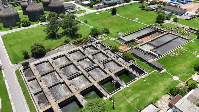 Complexo de saneamento com tanques de lodo ativado utilizados no tratamento de esgoto, representando engenharia ambiental, sa&uacute;de p&uacute;blica e solu&ccedil;&otilde;es sustent&aacute;veis para &aacute;reas urbanas.