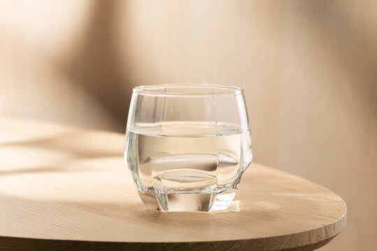 A clear glass of clean drinking water placed on a wooden table in soft natural light, symbolizing hydration, health, simplicity, and the benefits of drinking water for the body.
