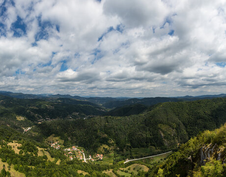 Mountain and forest with dramatic cloudy sky - Powered by Adobe
