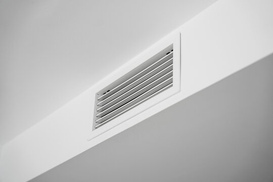 White ceiling air vent grille in modern home interior, clean HVAC ventilation system detail with minimal architectural lines