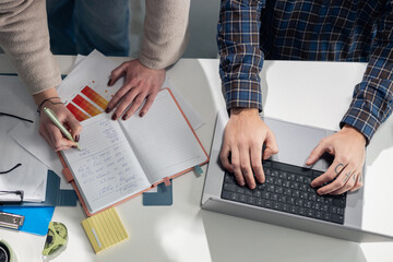 Business colleagues collaborating on strategy with laptop and notebook