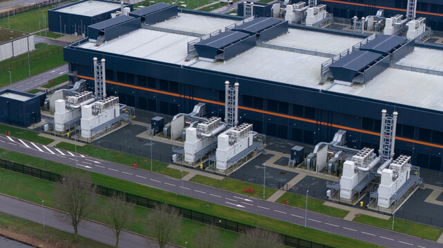 Aerial view of the vast Data Center Agriport, its dark metallic hues contrasting with the neat rows of equipment and roads, Middenmeer, Netherlands.