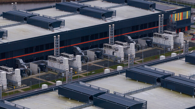 Aerial view of the vast, geometric Agriport data center complex, a modern industrial landscape punctuated by rows of cooling units, Middenmeer, Netherlands.
