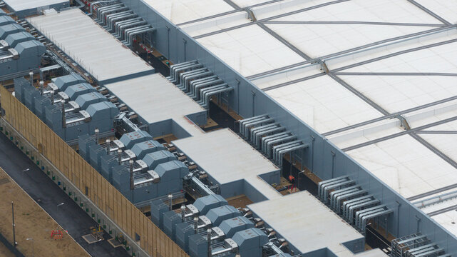 Aerial view of a newly built datacentre in Waltham Cross, highlighting AI-driven cloud computing infrastructure with close-up views of emergency backup generators and advanced cooling systems.