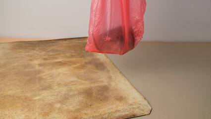 Brown rat in a red plastic bag.