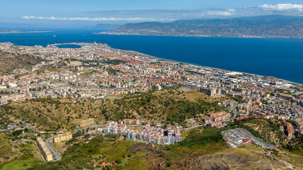 Fototapeta premium Aerial view of the Strait of Messina. It is a narrow strait between the eastern tip of Sicily and the western tip of Calabria, in Southern Italy. It connects the Tyrrhenian Sea with the Ionian Sea.