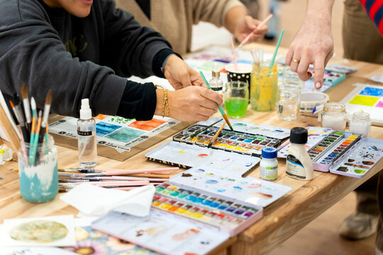 Adults learning watercolor painting during art class