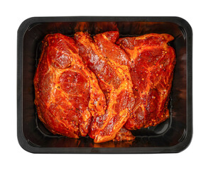 Top view of raw beef steaks coated in spicy marinade with mustard seeds packed in black plastic tray, fresh meat preparation for grilling or roasting isolated
