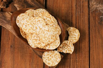 Flat lay of Traditional Indonesian tempe chips or keripik tempe served on wooden table