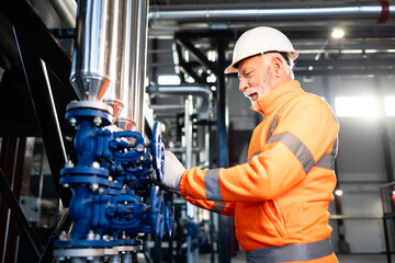 Senior engineer working on valves in industrial plant