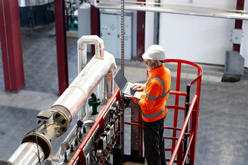 Engineer working on laptop in industrial power plant