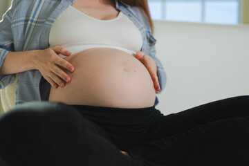 Pregnancy motherhood people expectation future. Pregnant woman hands touching big belly. Girl hugging her tummy enjoying pregnancy at home. Maternity tenderness parenthood new life concept