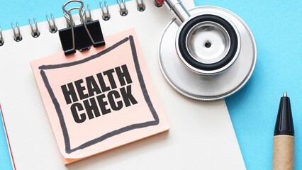 HEALTH CHECK words on a piece of paper next to a stethoscope.