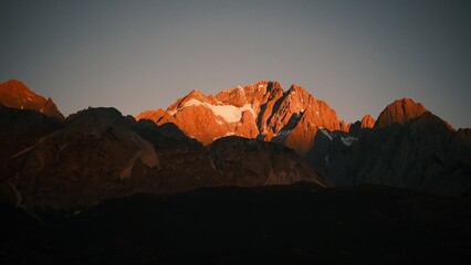 Sunrise Glow on Jade Dragon Snow Mountain over Lijiang Old Town, Yunnan, China. © Jean