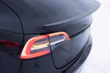 Car on the road with tail left yellow light. Flashing turn signal indicating the correct direction. Tail light signals for turning a car on the street