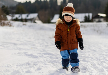 Child walks in the snow during a cold winter and has fun