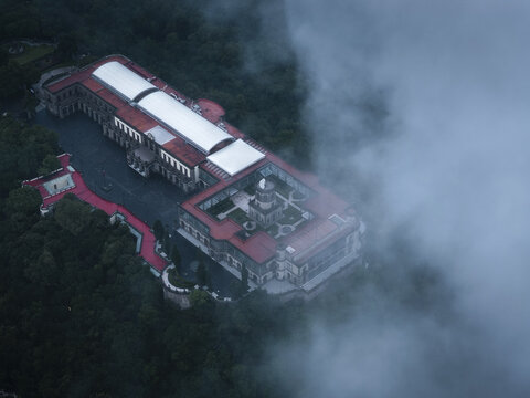 Aerial view of Chapultepec Castle, partially obscured by swirling mist, creating a serene yet imposing scene, Mexico City, Mexico.