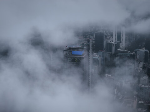 Aerial view of ghostly skyscrapers piercing through a thick blanket of fog, obscuring Paseo de la Reforma's urban landscape, Mexico City, Mexico.