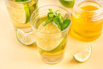 Hot mojito tea cocktail with rum, mint and lime slices, viral cold winter season warming motty - mojito version, with honey and ingredients on table background