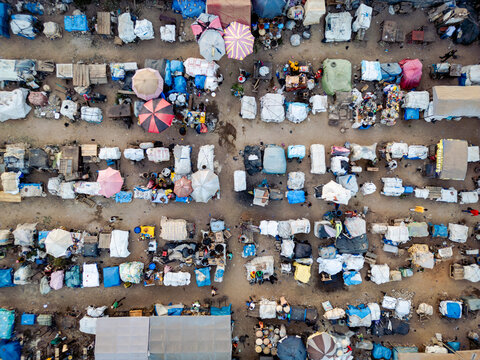 Aerial view of a bustling Lagos Street market, with colorful umbrellas dotting the landscape amidst tightly packed stalls, Kaduna, Kaduna, Nigeria.