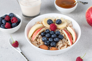 Fun breakfast for kids - sweet oatmeal shaped owl with blueberries, raspberries, apple, honey and almonds