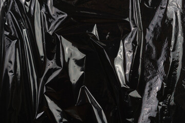 Naklejka premium high-quality image of wrinkled black plastic film with expressive creases and highlights, creating an overlay effect and a modern transparent aesthetic