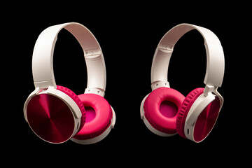 Pink and white headphones isolated on a black background.
