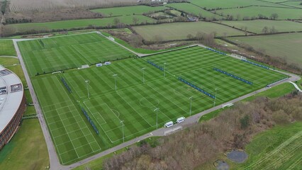 Aerial view of manicured football pitches, a symphony of green and white stripes under a muted sky, a testament to precision and dedication, Sileby, England, United Kingdom.