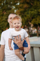 Dad and son walking in the park. Father holding child on the hand