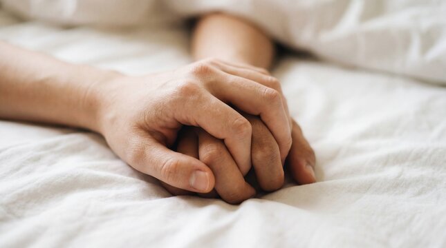 Two hands holding on white sheet closeup intimate touch comforting connection calm tenderness