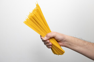 Męska dłoń trzymająca pęczek spaghetti
