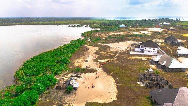 Aerial view of the landscape where the river meets the land, with buildings and vegetation, Olu Ama, Rivers State, Nigeria.