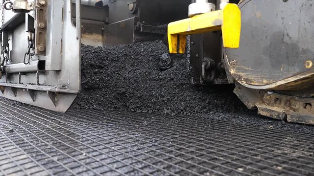 Special machinery making road in countryside area. Compactor constructing highway. Heavy machinery repairing road. Slowly driving roller laying new asphalt layer. Roadwork process. Roadway repair