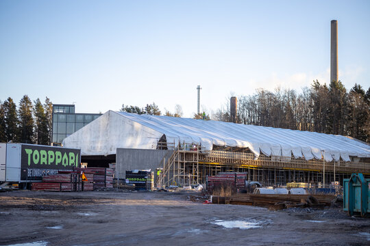 A construction site on Meritie street in Finnoo featuring a temporary fabric shelter tarp covering the unfinished structure to protect work from weather near metro station