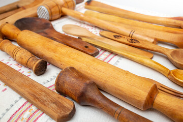 Many wooden spoons and spatulas on a white canvas towel, side view perspective close up