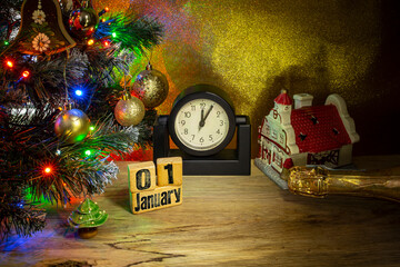 First day of january stamped on wooden cubes under a decorated christmas tree next to a clock , new yeas eve party conceptual backdrop