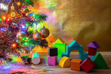 Warm setting with colorful wooden cubes under a lit christmas tree, long exposure photography , light painting