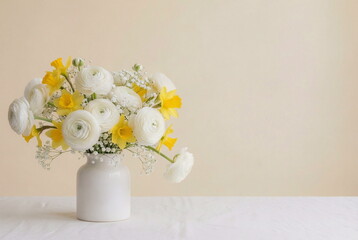 Vase with flowers bouquet on table with copy space card. White ranunculus and yellow daffodils on pale beige background. Greeting card , floral card, holiday  still life