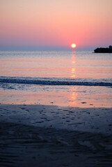 Die Sonne steigt aus dem Meer und f&auml;rbt den Himmel rosa.