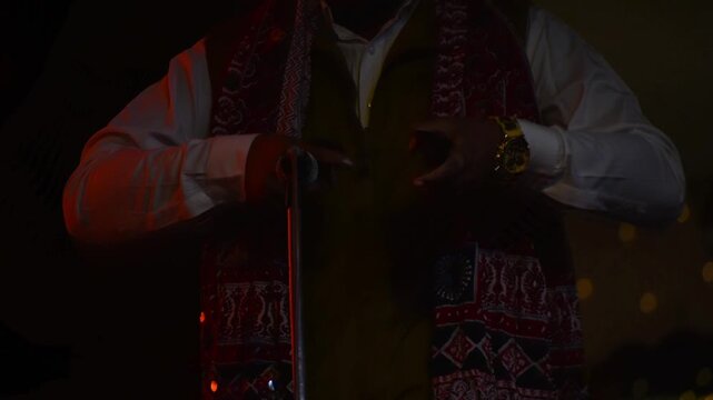 Hand shots of traditional Rajasthani folk musician playing Khartal on stage. hand movement, texture of the instrument, and live folk performance mood.