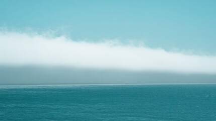 Fototapeta premium Vast Ocean Horizon Under a Thick Band of Fog and Clear Blue Sky water