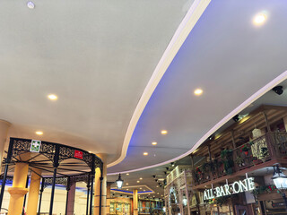 Naklejka premium Manchester shopping mall interior with ornate balconies,All Bar One festive lights, and busy crowd