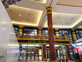 Naklejka premium Interior of a Manchester shopping Trafford Centre with marble columns, bright ceiling lights, and sign signage