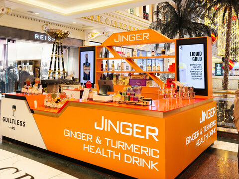 Jinger Ginger and Turmeric Health Drink Stand in Manchester Shopping Mall with Bright Orange Branding