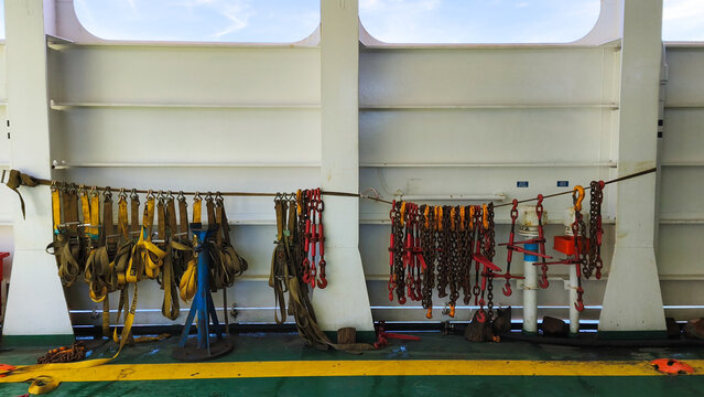 Heavy duty maritime lashing chains and ratchets for cargo securing on a vessel deck.