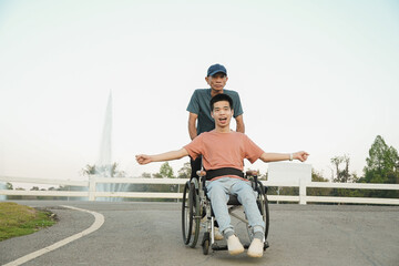 A confident outdoor lifestyle moment of a young wheelchair user enjoying fresh air in a park with family support. Natural light scene expressing freedom, joy, and inclusive everyday living.