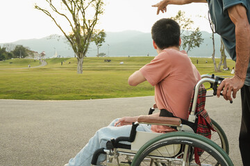 An outdoor lifestyle moment of a wheelchair user exploring a park with family guidance and support. Natural light scene expressing trust, direction, confidence, and inclusive everyday living.